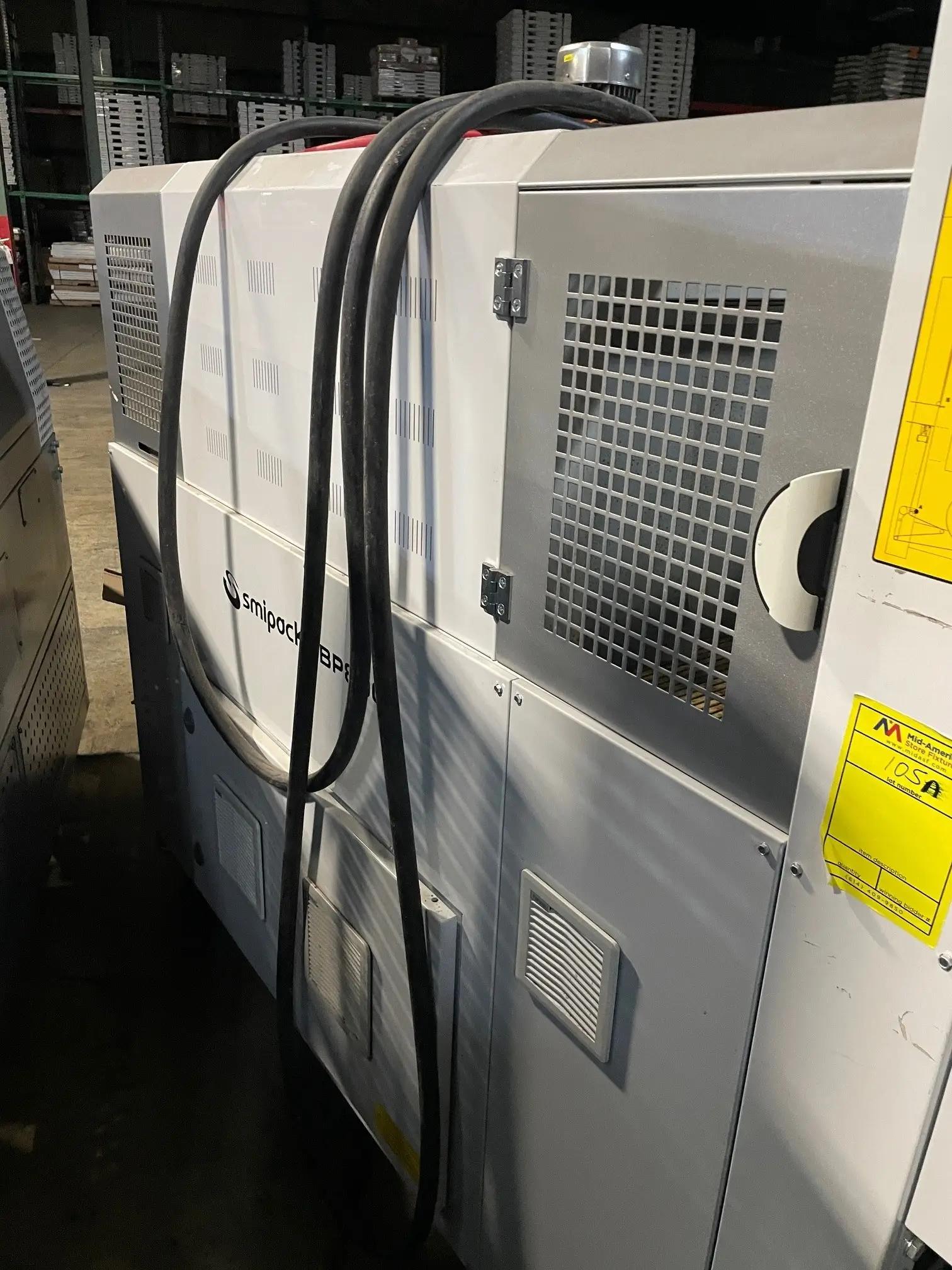 Industrial packaging machine with cables in a warehouse setting.