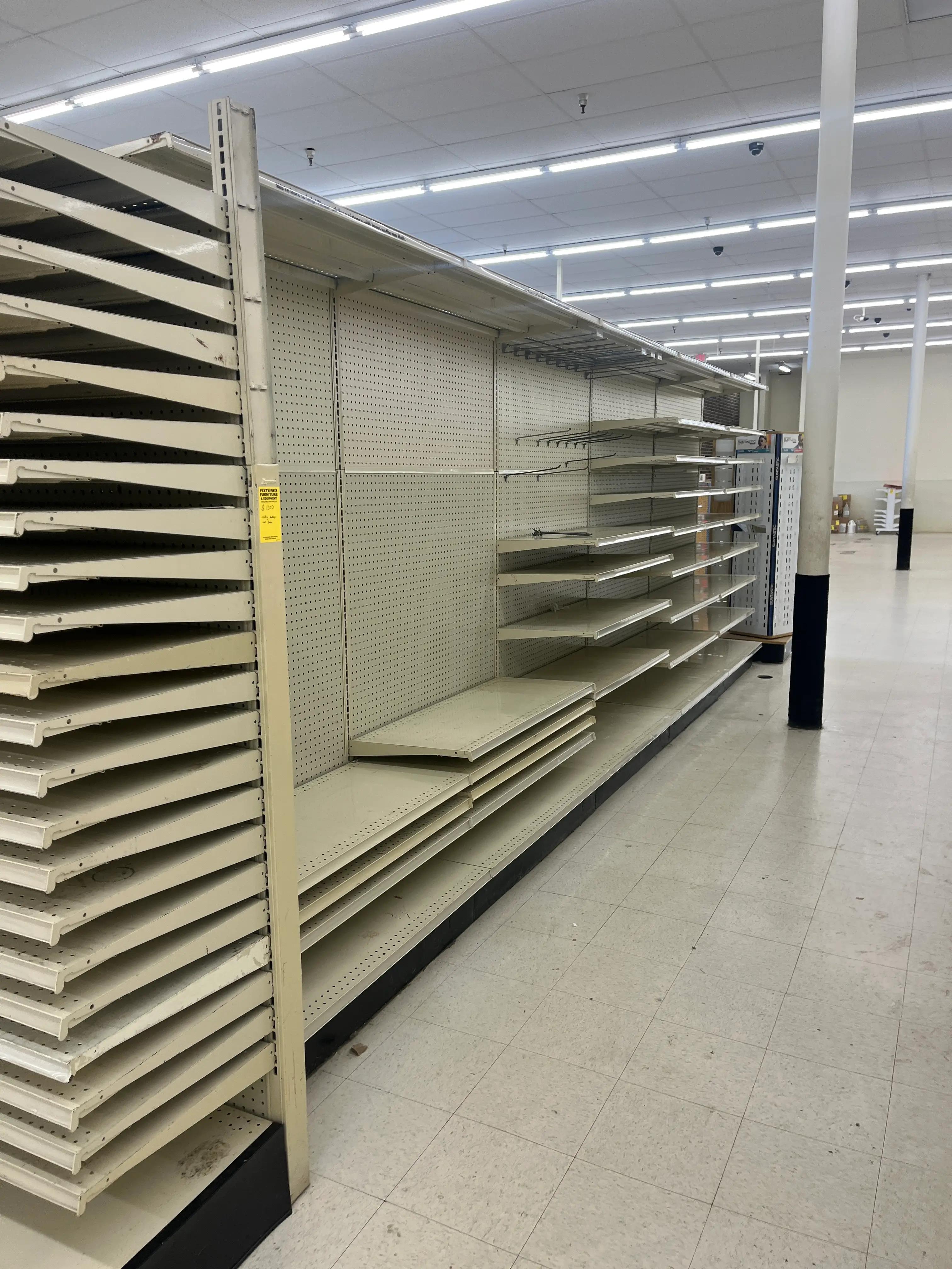 Empty store shelves in a brightly lit retail space, highlighting a completed shelving installation by Mid America.