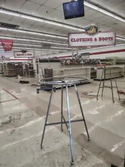 Retail round clothing rack display fixture in store environment for apparel merchandising and sales floor layout