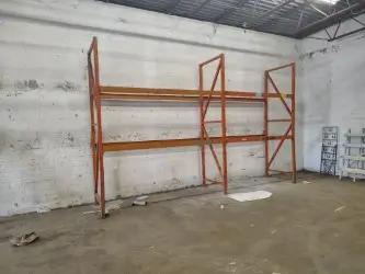 Industrial pallet racking system with orange beams for warehouse storage and bulk inventory organization