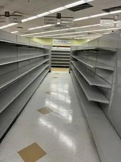 Empty retail gondola shelving aisles with metal shelves for store fixture resets and liquidation inventory
