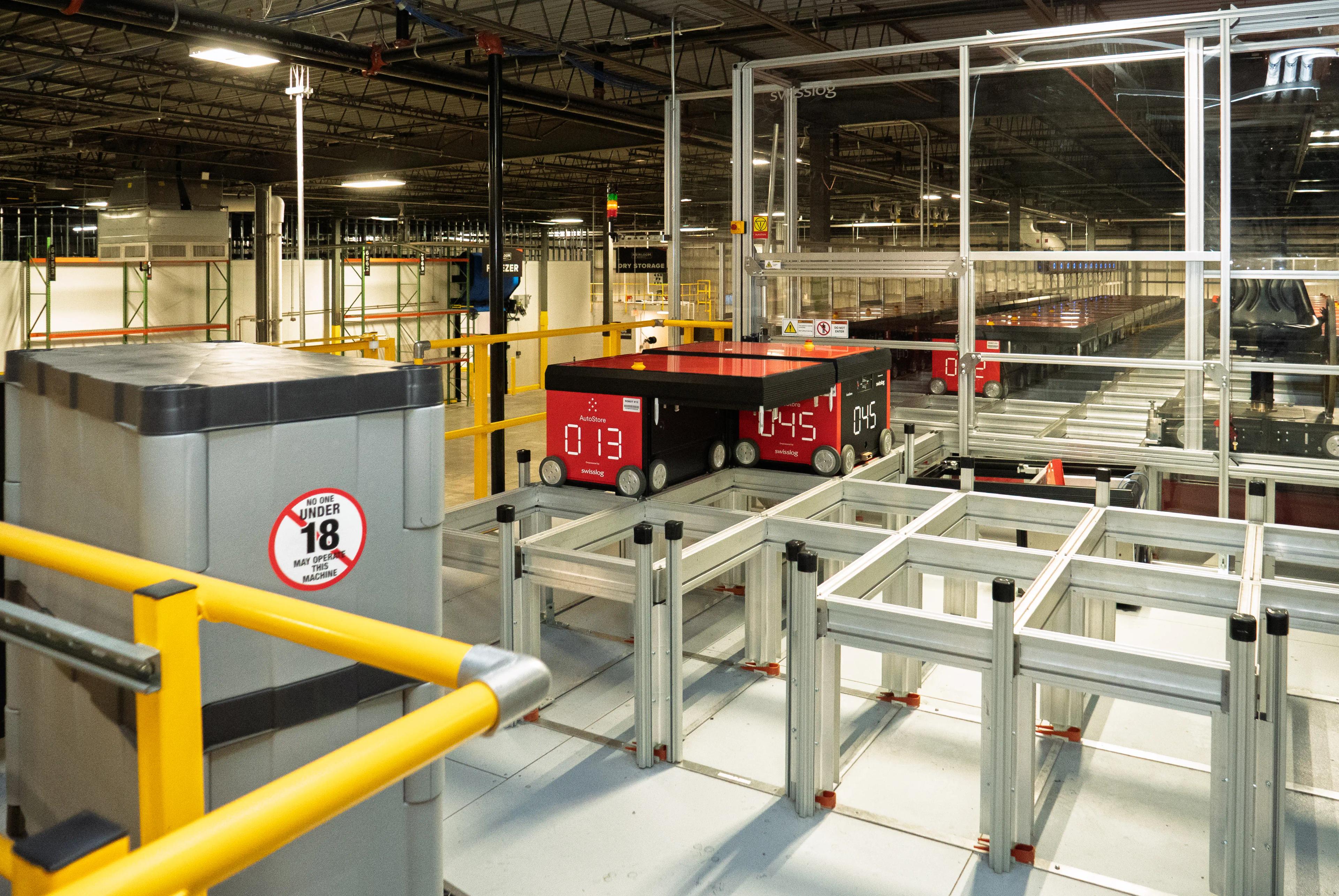 Automated warehouse system with robotic units on tracks inside a large facility.