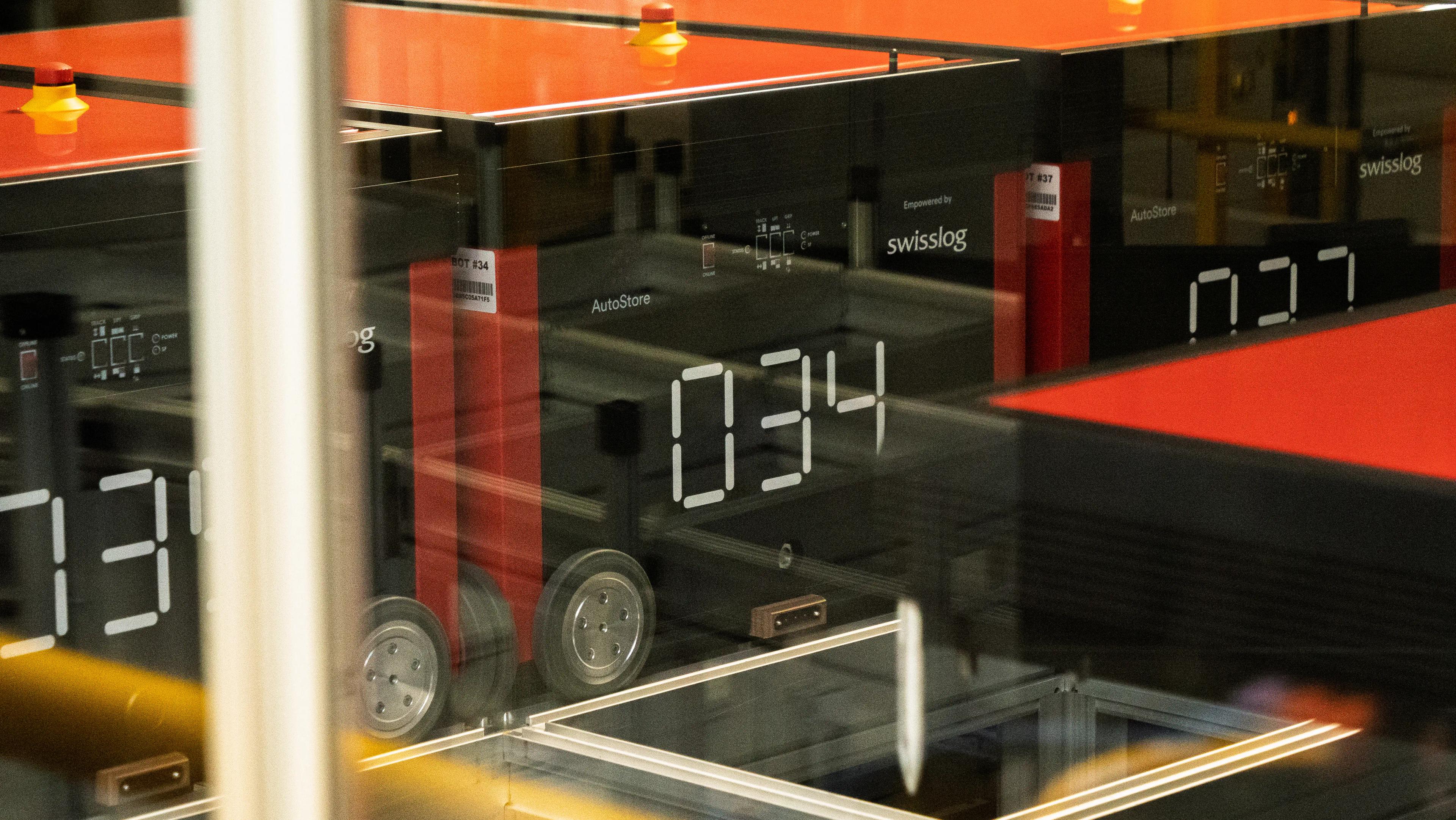 Close-up of an AutoStore robotics system with visible numbers on the displays and red tops, used for automated warehousing.