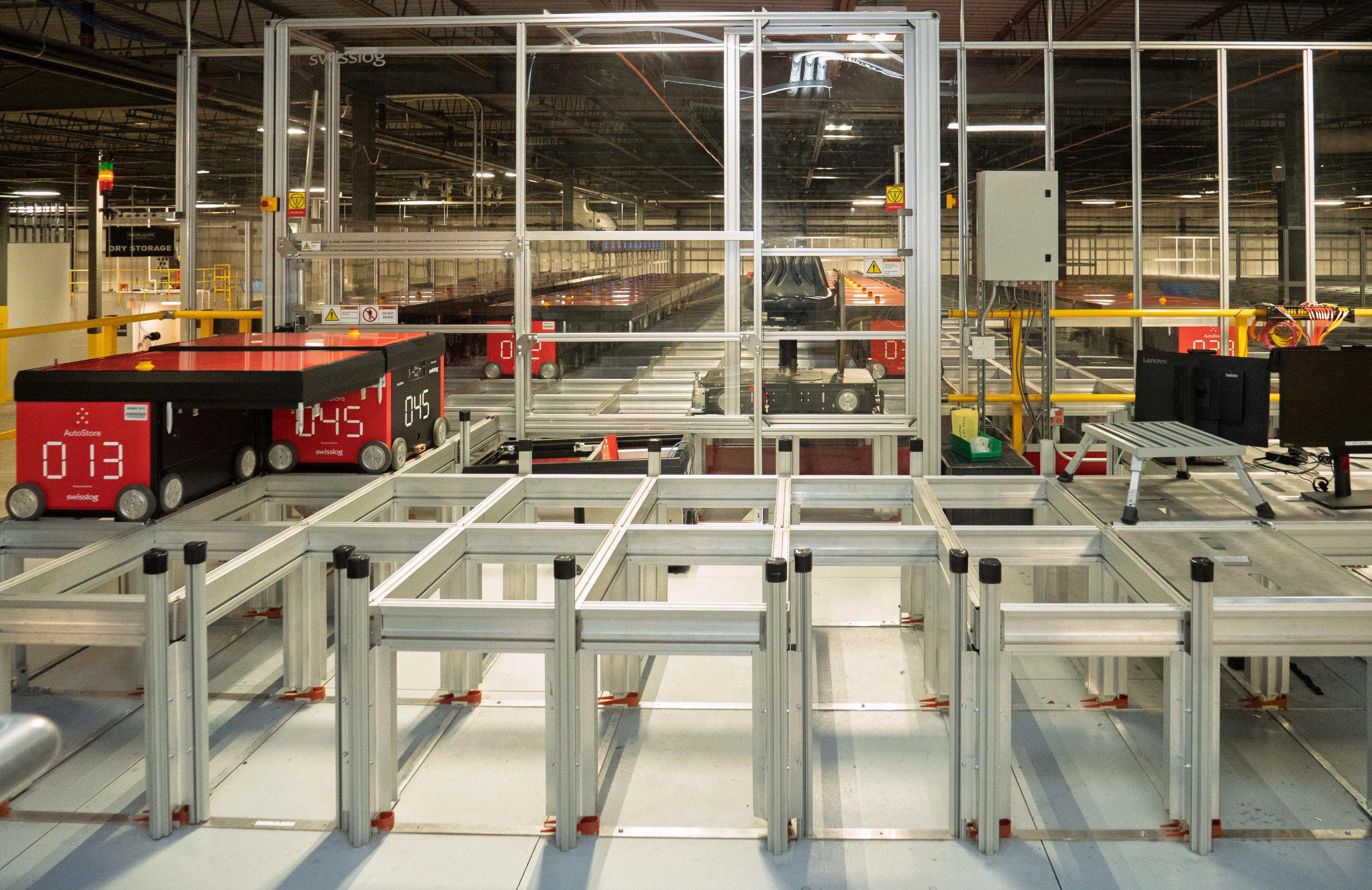 Automated warehouse with robotic systems and conveyors in use for logistics and storage solutions.