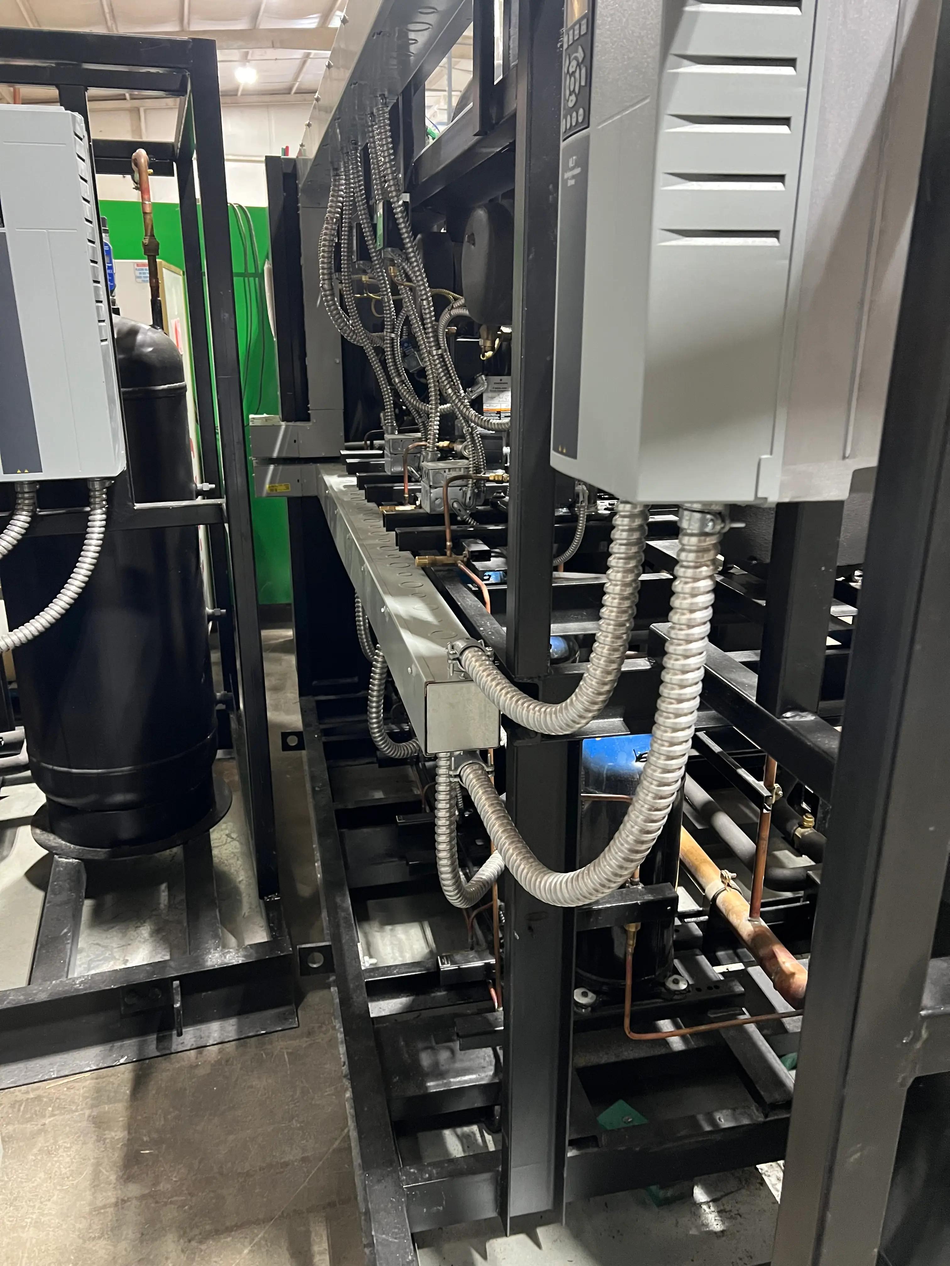 An industrial machine setup with various cables and components, featuring metal framework and connections.