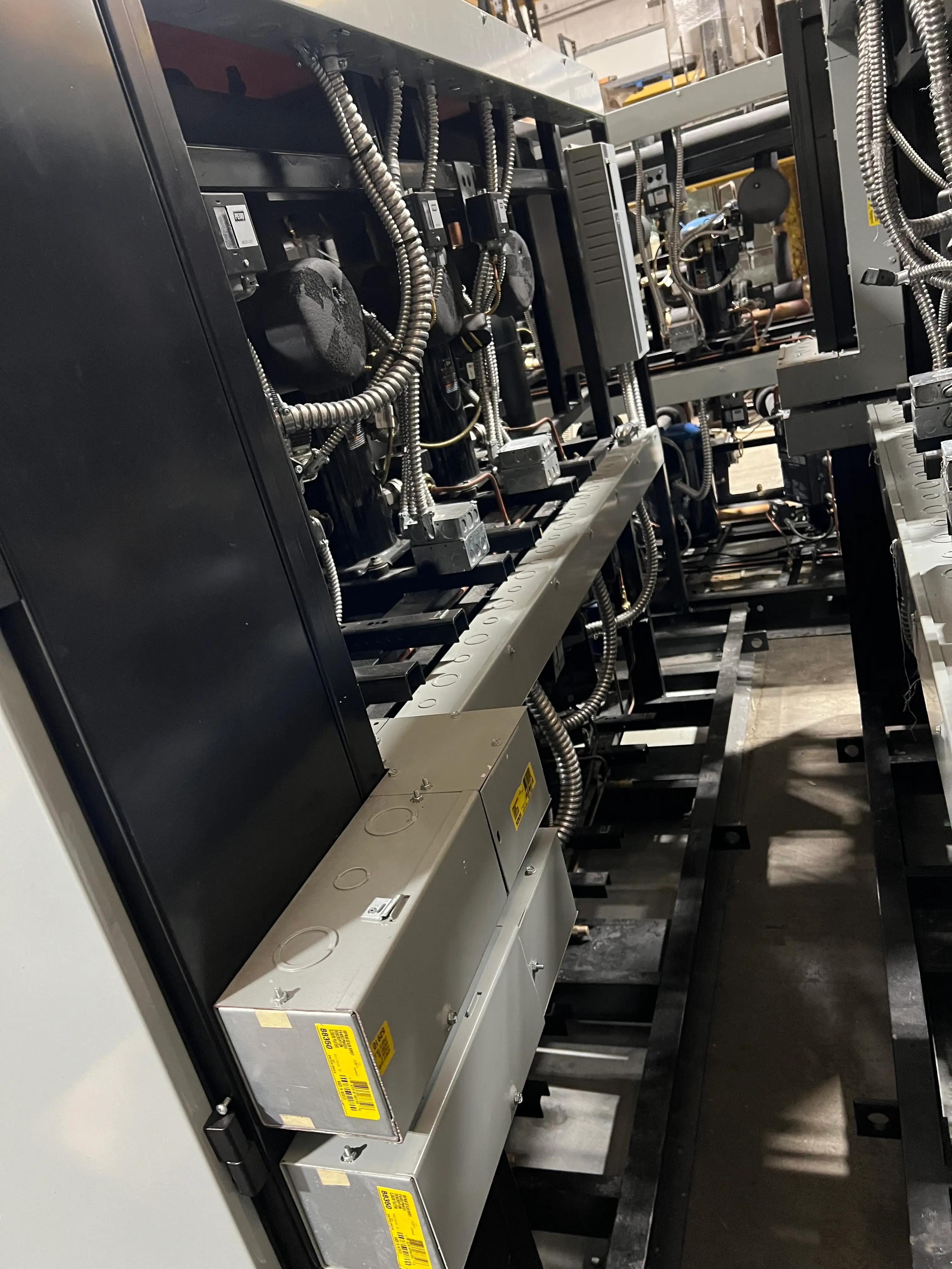 View of industrial machinery with visible wiring and electrical components in a factory setting.