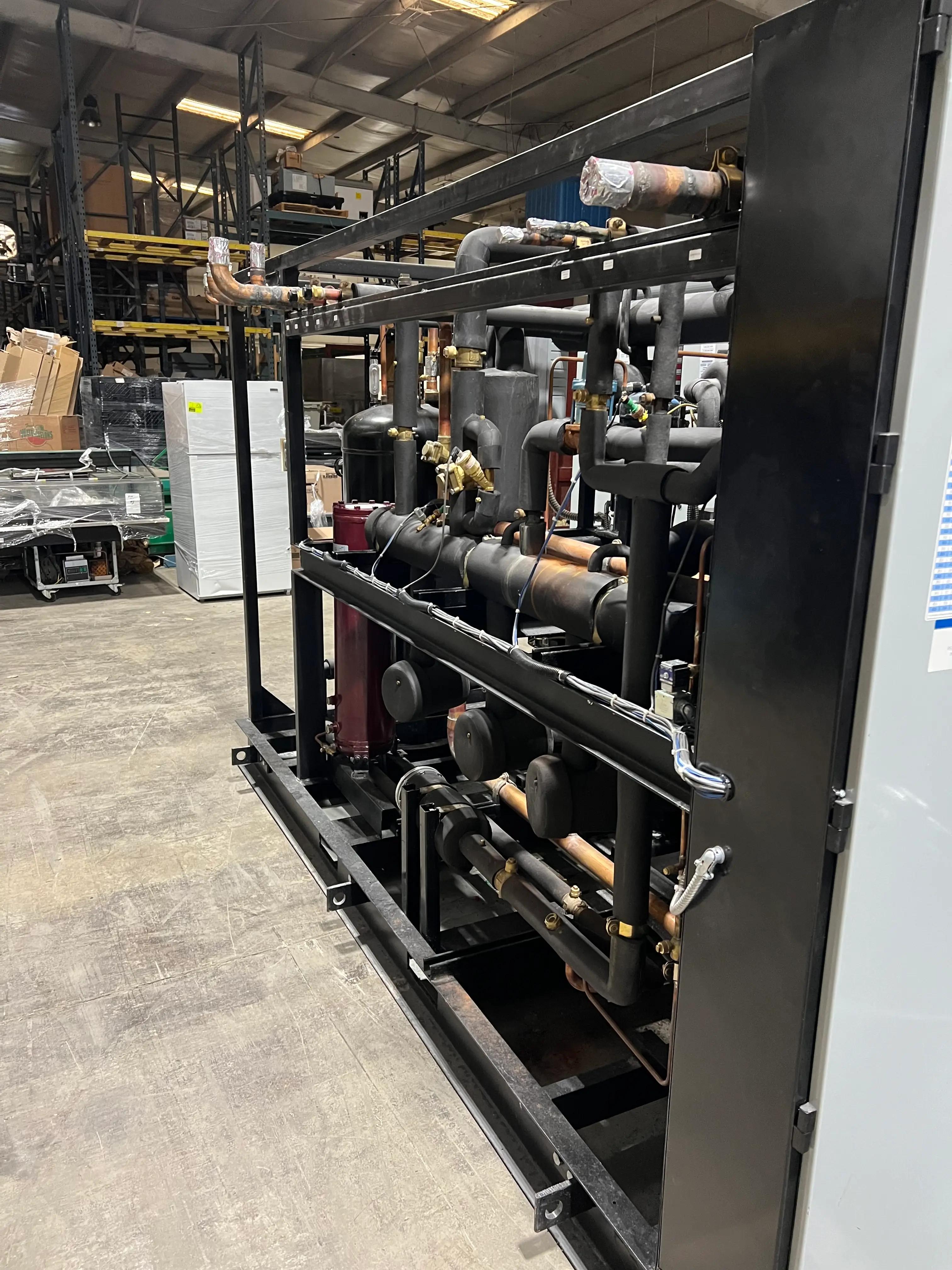 Warehouse interior with industrial machinery featuring complex pipe systems and metal structures.