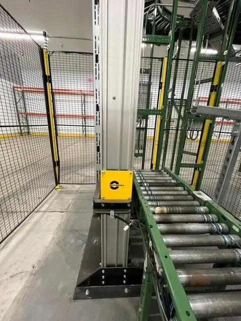 Industrial setup featuring metal rollers, a vertical support beam, and safety fencing, highlighting a project by Mid America.
