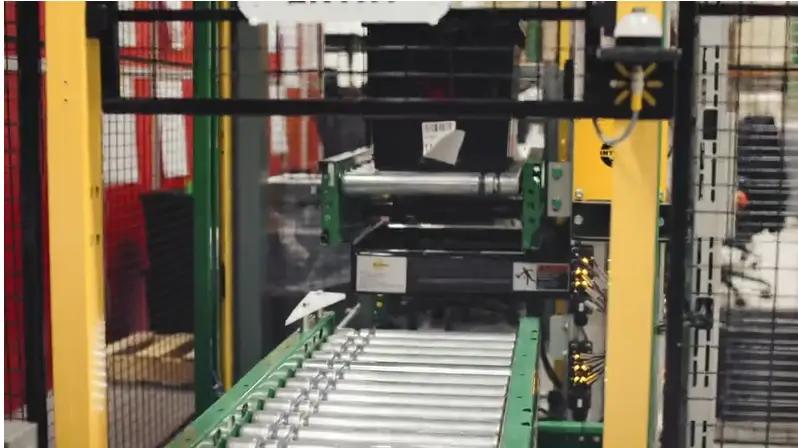 Industrial machinery featuring a conveyor belt and rollers, enclosed in a safety cage, showcasing a project by Mid America.