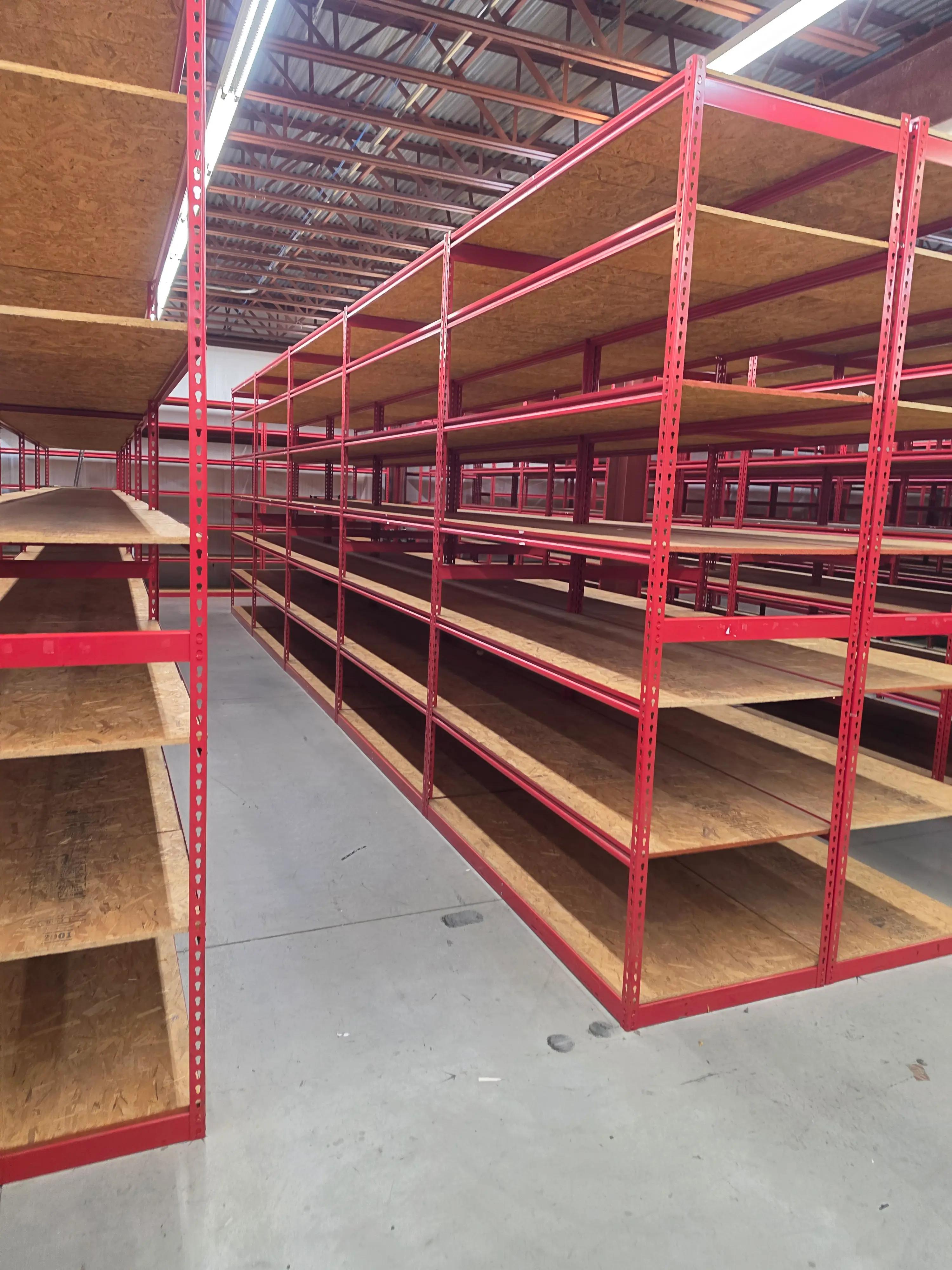 Red metal shelving units with wooden shelves in a warehouse, displaying storage solutions by Mid America.