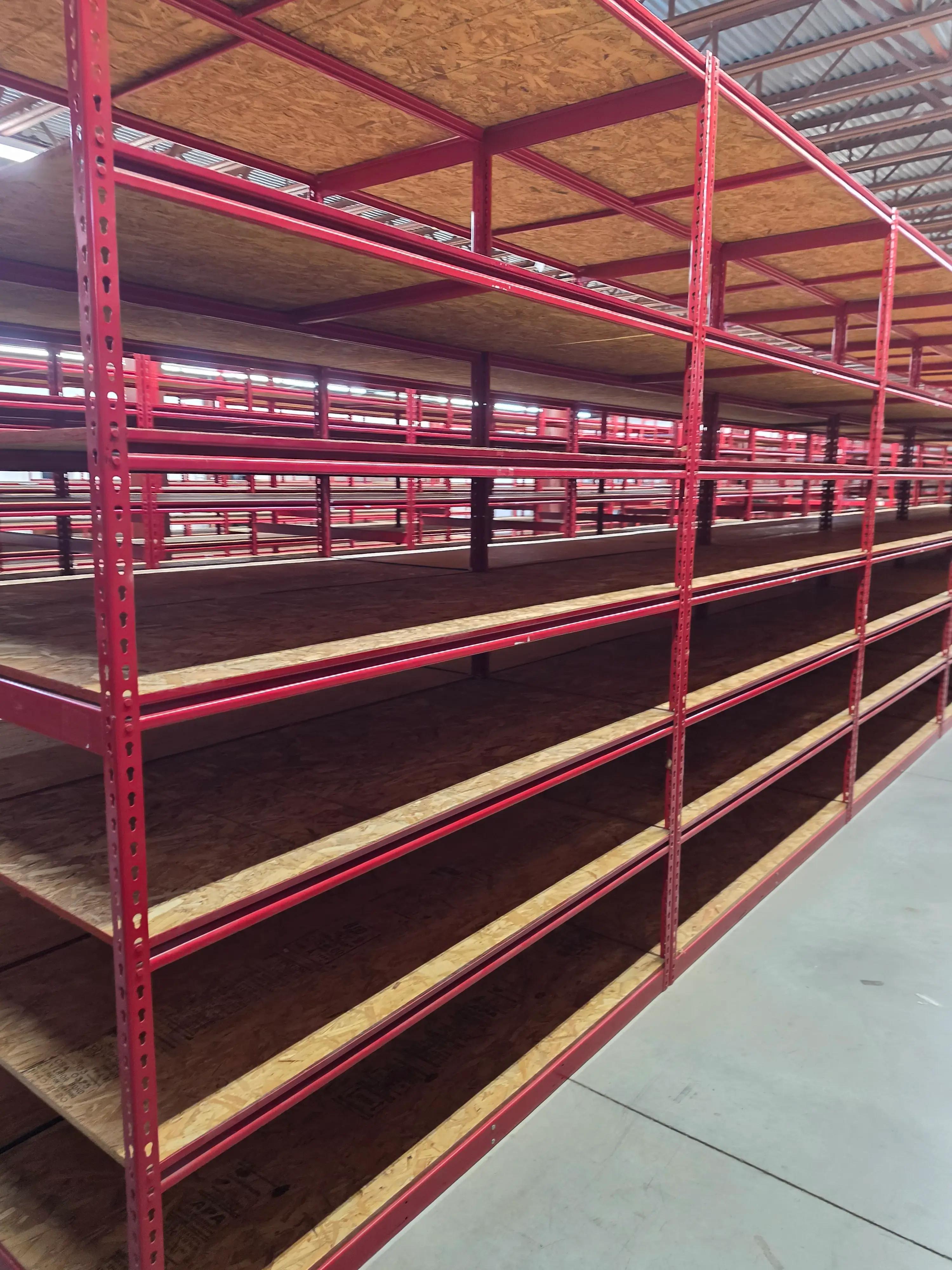 Large industrial shelving units with red metal frames and wooden shelves in a warehouse setting, installed by Mid America.